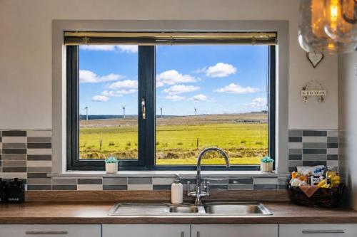 a kitchen window with a view of a field at Wildeston in Thurso