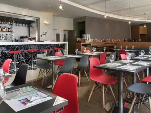 a restaurant with tables and red chairs and a bar at ibis Valparaiso in Valparaíso