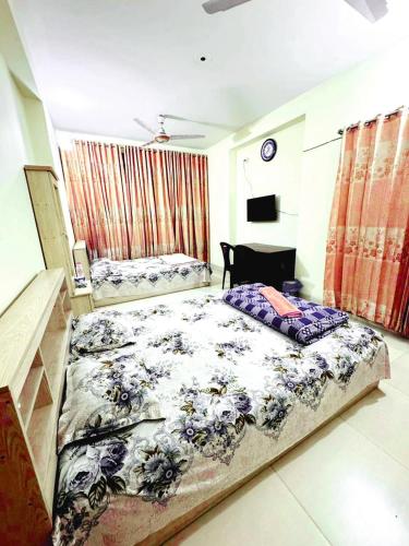 a bedroom with a large bed and a desk at Ast Guest House in Dhaka