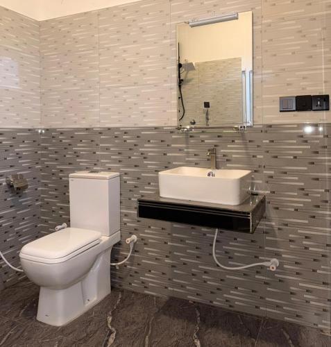 a bathroom with a toilet and a sink at Skylurk Transit in Negombo