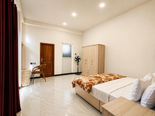 a bedroom with a bed and a desk and a chair at Skylurk Transit in Negombo