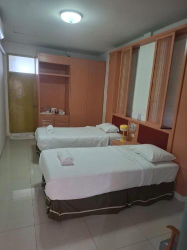 a hotel room with two beds and a bathroom at Happy 2 Pratunam Hotel in Bangkok