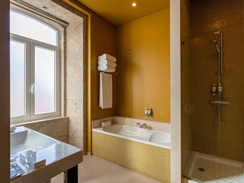 a bathroom with a tub and a sink and a shower at Pestana Palacio do Freixo, Pousada & National Monument - The Leading Hotels of the World in Porto
