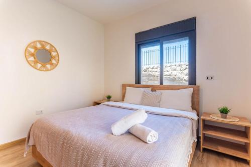 a bedroom with a bed with a stuffed animal on it at Echo 1-BR Apartment In Ejdabra Batroun 