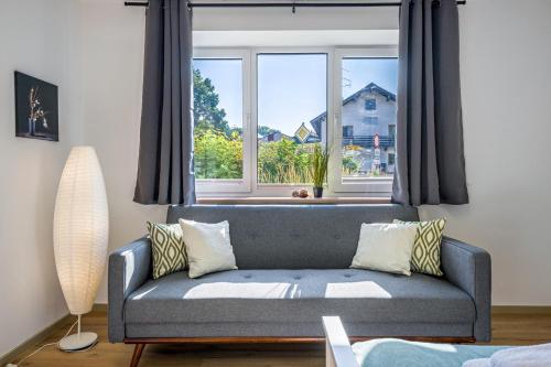 a living room with a couch and a large window at Romy in Reischach