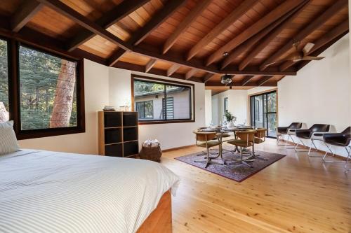 a bedroom with a bed and a table and chairs at The Graceful Dodeca Treehouse Coalcliff 
