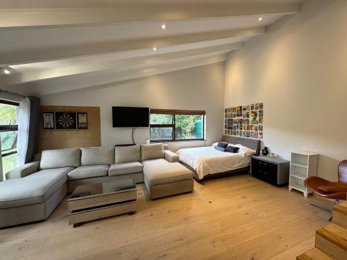 a living room with a couch and a bed at Upper Constantia Entertainers dream! in Cape Town
