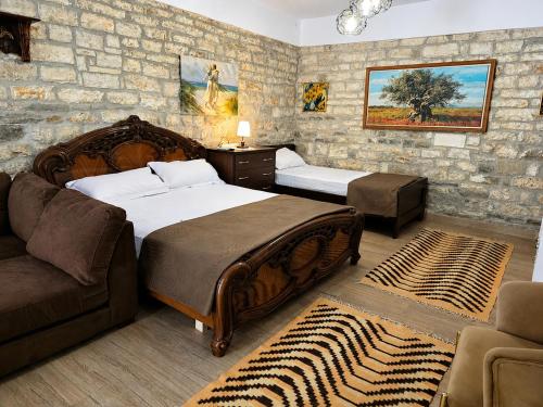 a bedroom with two beds and a couch at Hotel Taraca Gorice - UNESCO quarter in Berat