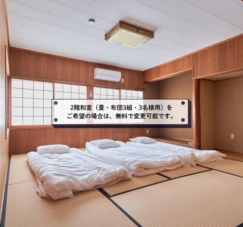 a room with a bed with a sign on the wall at 一棟貸しホテル Shirahama WAKO in Shirahama