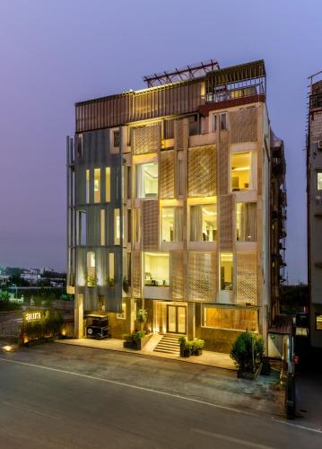 an apartment building with a lit up facade at night at Oraka by My Downtown Aura Hotel in Udaipur