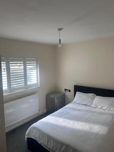 a bedroom with a white bed and two windows at Double Room Private Bathroom Parking South Croydon in Addington