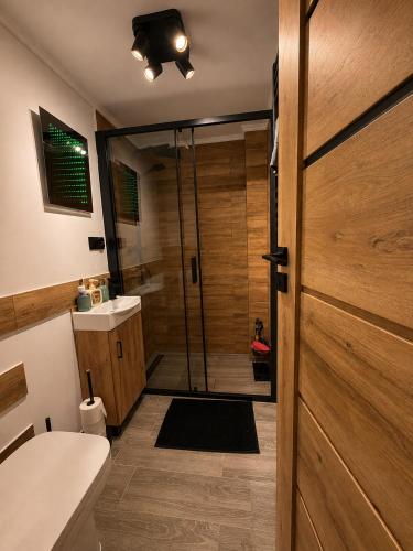 a bathroom with a shower and a wooden door at Pretty House in Słupsk