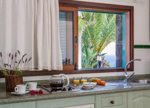 a kitchen counter with a sink and a window at Apartamentos Cancajos in Los Cancajos