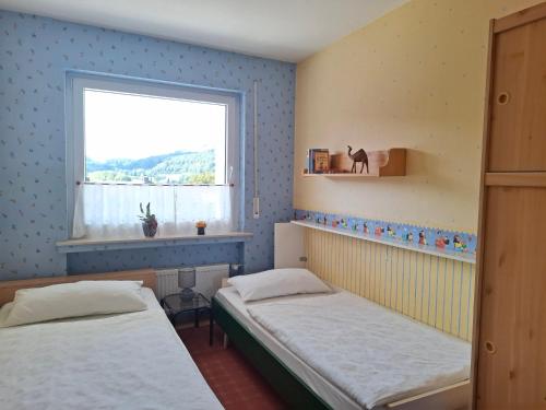 a bedroom with two beds and a window at Ferienwohnung Waltraud in Brilon