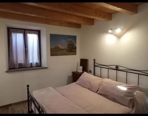 a bedroom with a bed and a window at b&b La Divina Pietra in Carnola