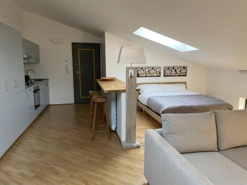 a bedroom with a bed and a kitchen with a couch at Laffittacamere Franciacorta in Passirano