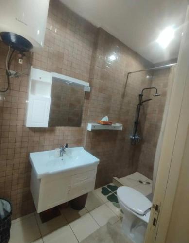 a bathroom with a white sink and a toilet at La pace in Libreville