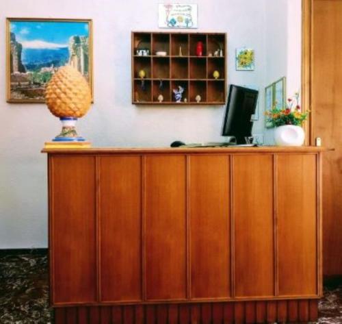 a wooden desk with a computer on top of it at Hotel Pensione Cundari in Taormina