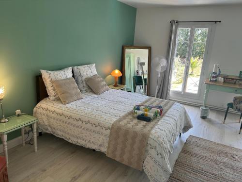 a bedroom with a bed and a table and a window at Sérénité in Saint-Vivien-de-Blaye