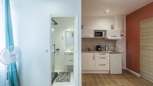 a kitchen with white cabinets and a sink and a mirror at Manu Chalons in Chalons en Champagne