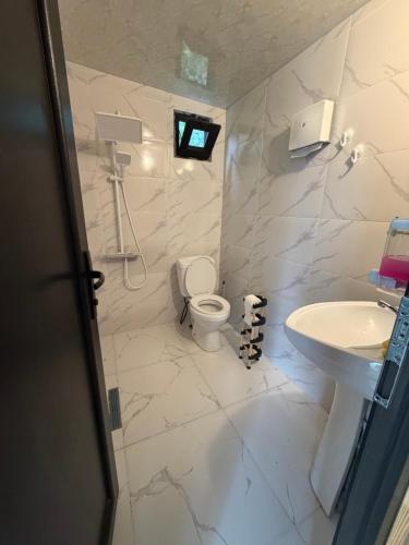 a white bathroom with a toilet and a sink at Merisi - Sunset Chalet in Merisi