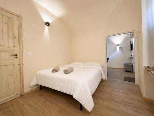 a bedroom with a white bed with two pillows on it at Tiny House nel cuore del Monferrato in Conzano