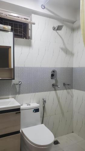a white bathroom with a toilet and a sink at Kathmandu Peace Guesthouse in Kathmandu