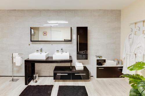 a bathroom with two sinks and a large mirror at Hôtel Saint Albert in Sarlat-la-Canéda