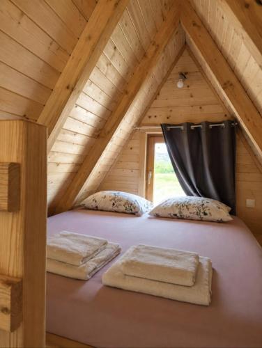 ein Bett auf dem Dachboden einer Blockhütte in der Unterkunft Tiny House 3-Imanje Terzić in Golubovci