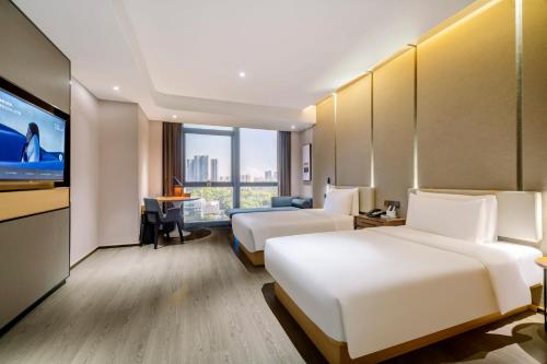 a hotel room with two beds and a flat screen tv at Atour S Hotel Nanshan Haofang Tianji Shenzhen深圳南山豪方天际亚朵S酒店 in Shenzhen