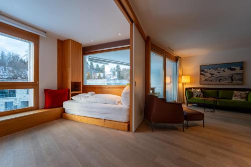 a bedroom with a bed and a large window at Sleek Mountain Escape Light and Airy in Flims