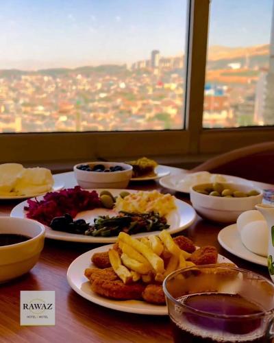 a table with plates of food on a table at Rawaz Hotel in As Sulaymānīyah