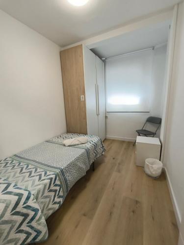a small bedroom with a bed and a window at Alojamiento La Paz in Linares