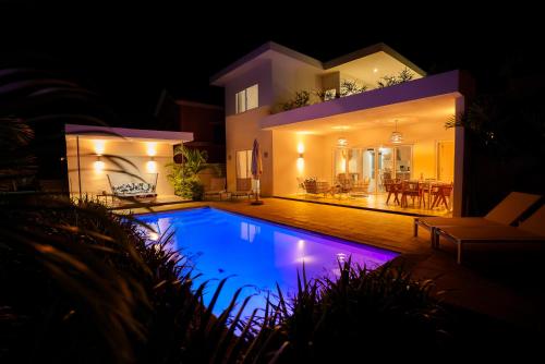 a house with a swimming pool at night at ELOMY VILLA in Albion