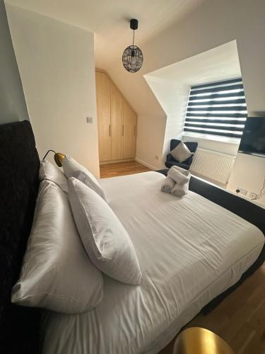 a white bed with white pillows in a bedroom at Spacious 4-Bedrooms Corporate Flat - Prime Location in Watford