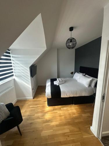 a bedroom with a large bed and a window at Spacious 4-Bedrooms Corporate Flat - Prime Location in Watford
