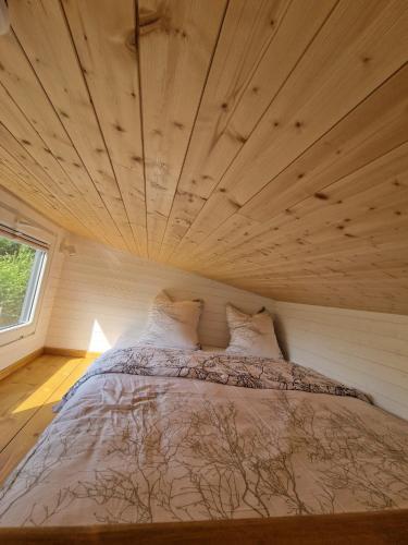 a bed in a room with a wooden ceiling at Little Luxe 2 in Amriswil