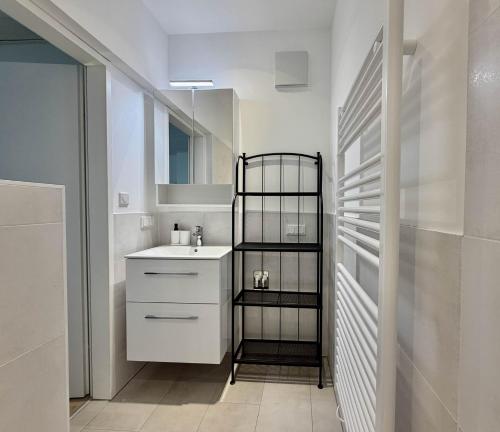 a white bathroom with a sink and a mirror at Payerbach Apartments in Payerbach