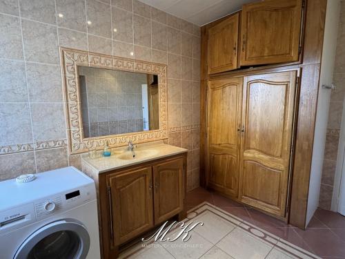 a bathroom with a washing machine and a sink at L'Arche in Saint-Dizier