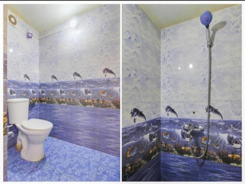 a bathroom with a toilet and a mural of birds at Jerrys Holiday Home in Merces