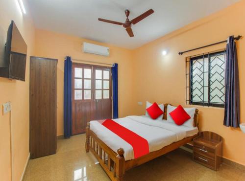 a bedroom with a bed with red pillows and a window at Jerrys Holiday Home in Merces