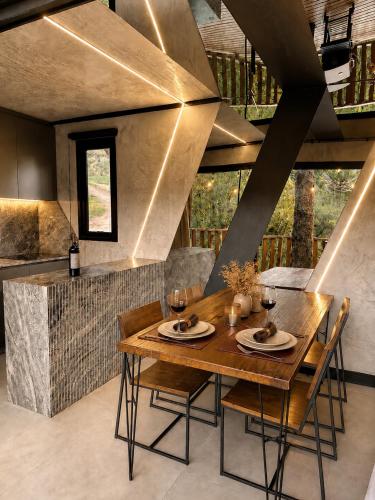 a dining room with a wooden table and chairs at Forte das Araucarias in Urubici