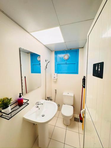 a bathroom with a white toilet and a sink at Majestic Inn in Abu Dhabi