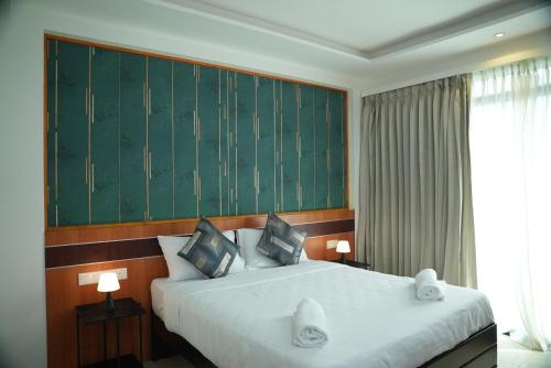 a hotel room with a large bed with two lamps at The R One in Male City