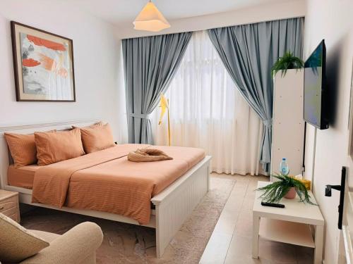 a bedroom with a bed and a couch and a window at Majestic Inn in Abu Dhabi