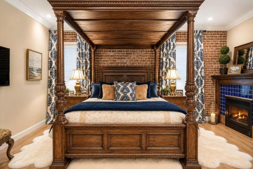 a bedroom with a wooden canopy bed with a fireplace at Historic Mansion-King Suite-The Royal Crown in Fort Smith
