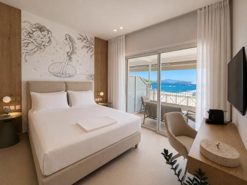 a bedroom with a large white bed and a balcony at Ventora Suites in Nydri