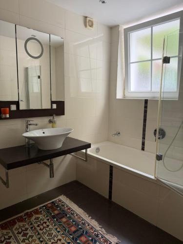 a bathroom with a sink and a tub and a window at Idyllisches Wohnen Weinberg in Bad Kissingen