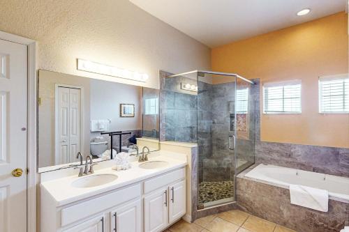 a bathroom with two sinks and a shower at Exclusive 3BR villa: pools near Disney magic in Kissimmee