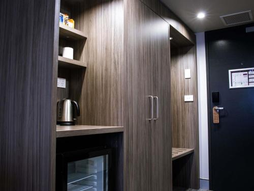 a bathroom with a wooden wall with a door at Mercure Tamworth in Tamworth